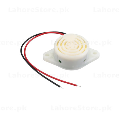 Active piezo buzzer angled view showing green polarity indicator dot and wire leads